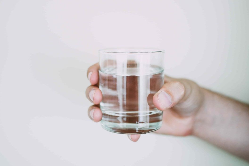 dry-fasting and electrolytes hand holding a glass of water